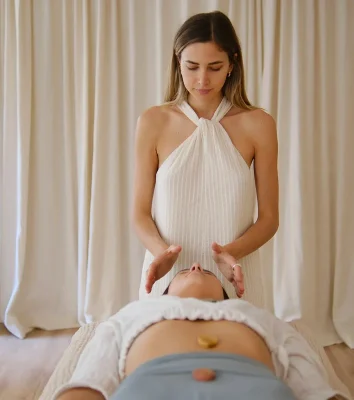 Practitioner holding her hands above a resting client during an energy session at Energy Studio Vienna